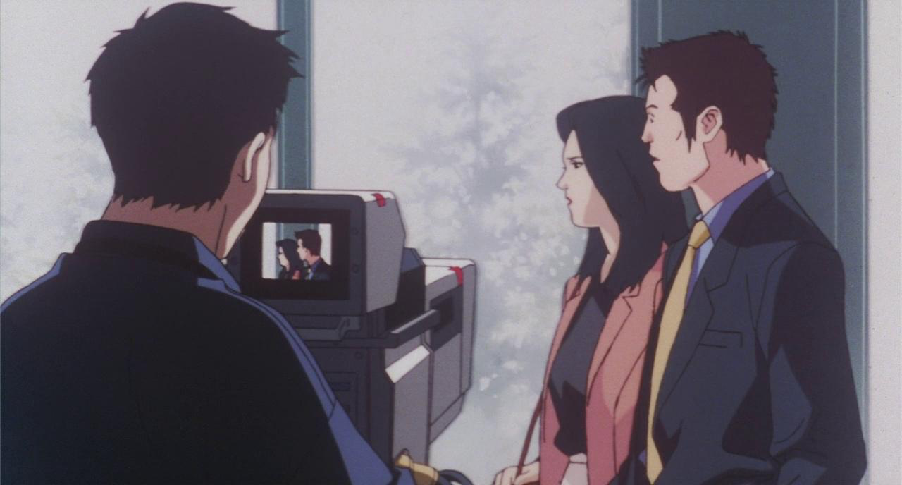 A man and woman being filmed for a movie